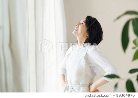 窗邊沐浴陽光的中年婦女 99304970