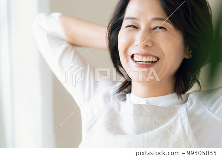 窗邊沐浴陽光的中年婦女 99305035