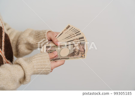 Woman hand holding Japanese Yen banknote stack. Thousand Yen money. Japan cash, Tax, Recession Economy, Inflation, Investment, finance and shopping payment concepts 99305185