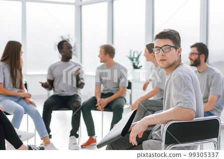 handsome guy sitting in a circle with like-minded person 99305337