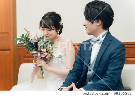 Bride and groom's men and women with bouquets in the bride's room / waiting room of the wedding hall (dress fitting / costume matching) Bride and groom's men and women with bouquets in the bride's room / waiting room of the wedding hall (dress fitting / costume matching) 99305592