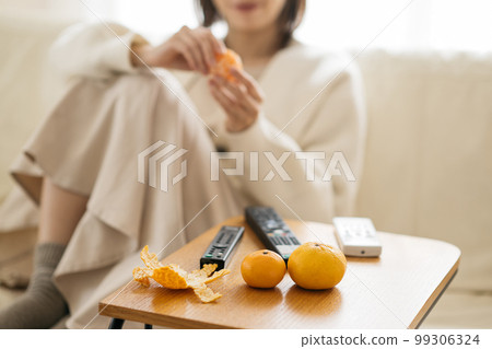 一個在房間裡放鬆的家庭主婦，一個看電視的女人 99306324