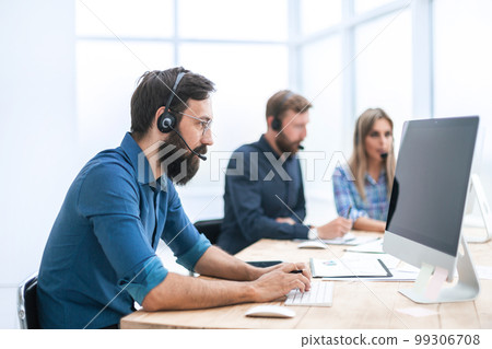 close up. business man in a headset working on a computer close up. business man in a headset working on a computer 99306708