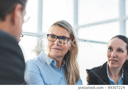 adult businesswoman discussing ideas with colleagues. office workdays adult businesswoman discussing ideas with colleagues. office workdays 99307224