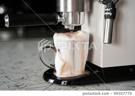 Coffee machine overfilled cup with coffee close up 99307778