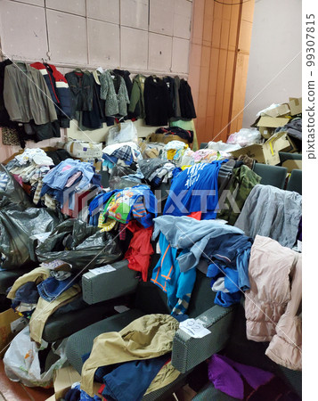 Person sorting second hand clothes by size and gender Person sorting second hand clothes by size and gender 99307815