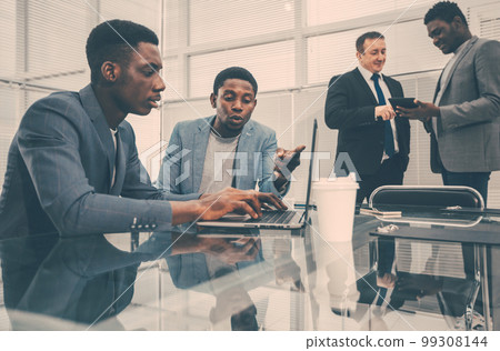 young employees using a laptop in the office. young employees using a laptop in the office. 99308144