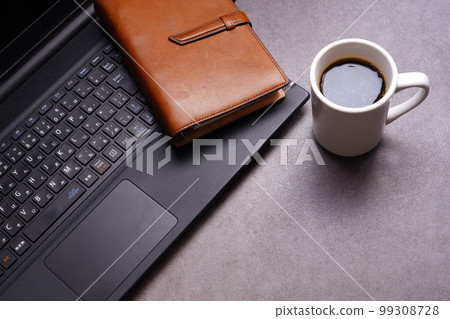 Desk work with a laptop, system notebook, and coffee 99308728
