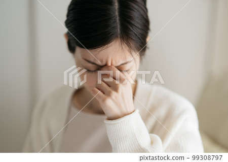 A woman suffering from itchy eyes due to headache and hay fever 99308797