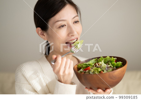 Woman eating salad 99309185