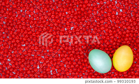Easter eggs with space for text on red heart candies background. Colorful easter eggs on red background. Top View. Copy Space. Spring dessert. Easter eggs with space for text on red heart candies background. Colorful easter eggs on red background. Top View. Copy Space. Spring dessert. 99310193