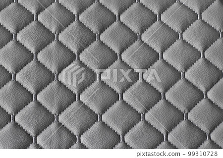 Quilted fabric pattern. The texture of the sofa is gray eco leather. Decorative background. 99310728