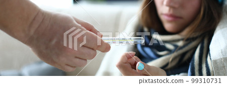 Sick woman person passes a thermometer closeup Sick woman person passes a thermometer closeup 99310731