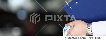 Car mechanic priemchik holds gloves and clipboard in car service 99310879