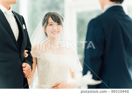 A bride walks along a virgin road to the chapel where the groom waits at the wedding hall 99310948
