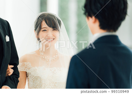 A bride walks along a virgin road to the chapel where the groom waits at the wedding hall A bride walks along a virgin road to the chapel where the groom waits at the wedding hall 99310949