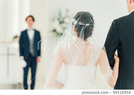 A groom/groom man waiting for a bride to walk on a virgin road at a wedding hall/chapel 99310950