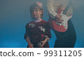 Little girl on stage in vintage dress, she sings into microphone and dances, her father plays an electric guitar. Color music is shining and smoke is billowing. Family time, creativity and hobbies 99311205