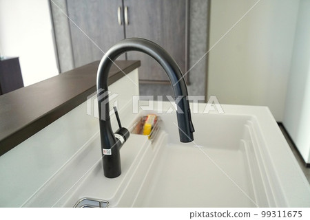 Kitchen in new house with black modern faucets Kitchen in new house with black modern faucets 99311675