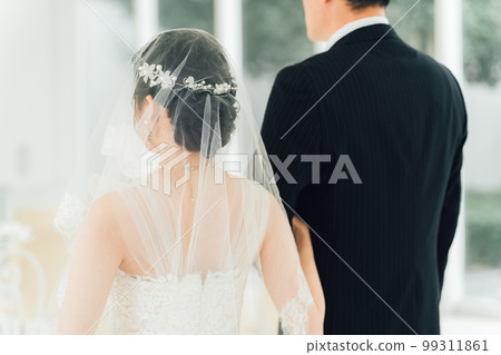A bride walks along a virgin road to the chapel where the groom waits at the wedding hall 99311861