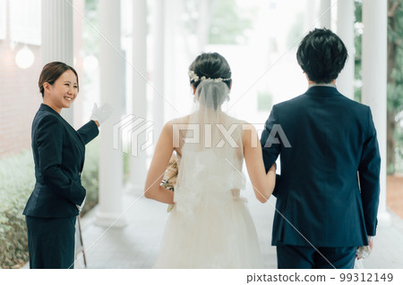 Wedding planner, door staff, hotelier woman and bride and groom (wedding) 99312149