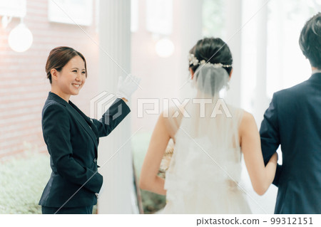 Wedding planner, door staff, hotelier woman and bride and groom (wedding) Wedding planner, door staff, hotelier woman and bride and groom (wedding) 99312151