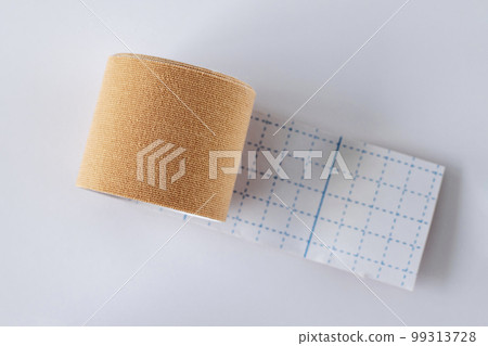 Roll of beige kinesio-tape on a white background, flat lay 99313728