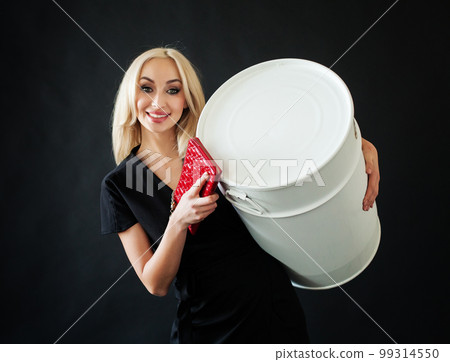Beautiful blonde woman wth make up and red clutch and white barrel on black background 99314550