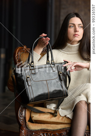 photo of a woman with a black leather bag with antique and retro look. indoors photo 99316597