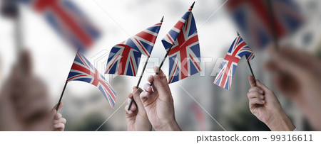 A group of people holding small flags of the United Kingdom in their hands 99316611