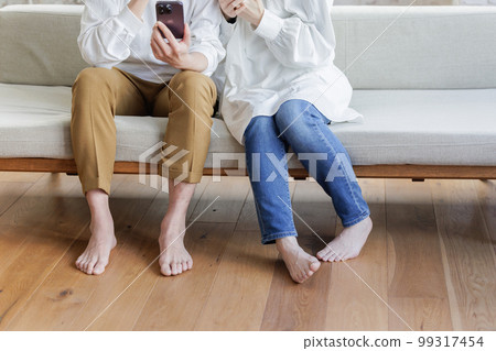 Men and women relaxing on the sofa Parts cut 99317454