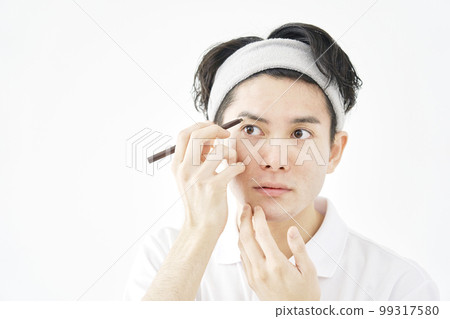 一個男人用眉筆劃眉毛 白色背景 99317580