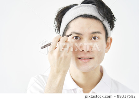 一個男人用眉筆劃眉毛 白色背景 99317582