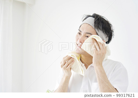 一個男人用毛巾擦汗 白色背景 99317621