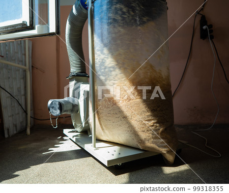 Vacuuming sawdust while sawing wood. Chip blower in furniture production. Vacuuming sawdust while sawing wood. Chip blower in furniture production. 99318355