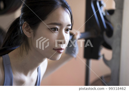 在健身房做槓鈴深蹲的年輕女子 99318462