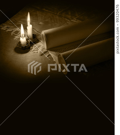 Ancient scroll lit by candlelight 99320476