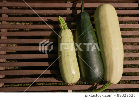 Three large zucchini are arranged in a row on a wooden table, top view with a place to copy. High quality photo 99322525