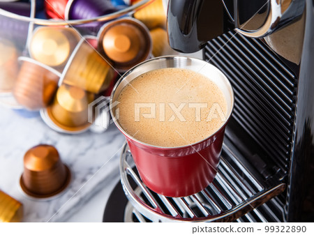 Espresso cup with pods capsules and home coffee machine on white background.Macro 99322890