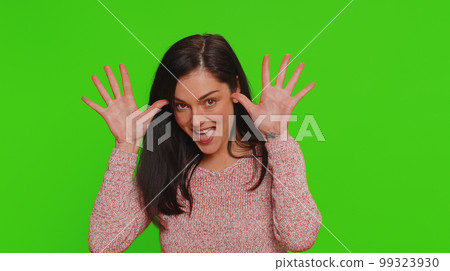 Funny joyful woman making playful silly facial expressions, grimacing, fooling around showing tongue 99323930