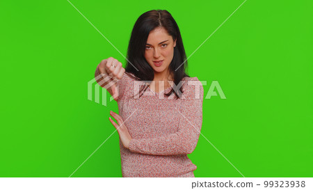Upset young woman girl in sweater showing thumbs down sign gesture disapproval dissatisfied dislike Upset young woman girl in sweater showing thumbs down sign gesture disapproval dissatisfied dislike 99323938