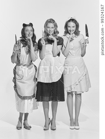 Retro style portrait of beautiful young women, housewives with cooking tools. Black and white image in vintage style 99324167