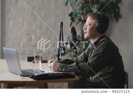 man in studio is recording podcast, audio content of interview on radio. Caucasian male 99325123