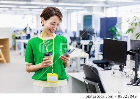 Business woman looking at a smartphone in the office Business woman looking at a smartphone in the office 99325849