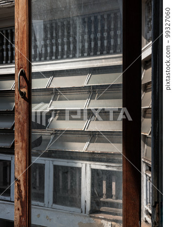 View through an the old window of ancient old building onto Antique steel awning windows the other side of the building. View through an the old window of ancient old building onto Antique steel awning windows the other side of the building. 99327060