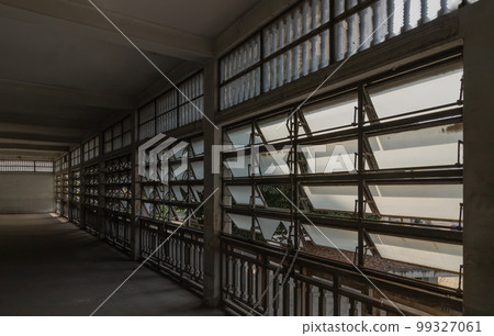 Ancient steel awning windows open for bright light streaming through the corridor interior the ancient building. Ancient steel awning windows open for bright light streaming through the corridor interior the ancient building. 99327061