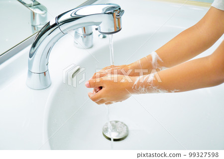 Hands of an infant who washes off the lather with running water 99327598