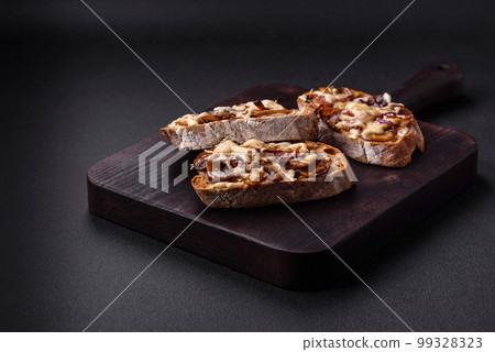 Delicious crispy toast or bruschetta with fried onion, champignon mushrooms and cheese 99328323