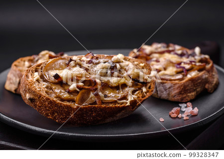 Delicious crispy toast or bruschetta with fried onion, champignon mushrooms and cheese 99328347
