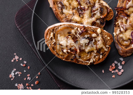 Delicious crispy toast or bruschetta with fried onion, champignon mushrooms and cheese 99328353